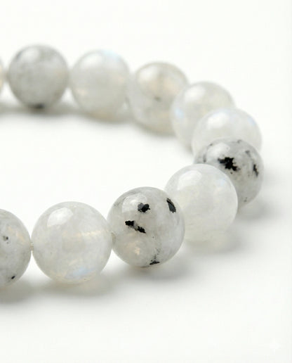 Natural Rainbow Moonstone beaded bracelet featuring 8mm white stones with black tourmaline inclusions on white background.