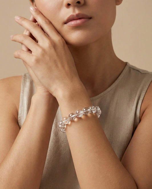 Natural Clear Quartz beaded bracelet with transparent round gemstones on black background.