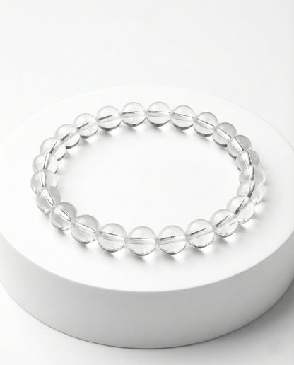 Natural Clear Quartz beaded bracelet with transparent round gemstones on black background.