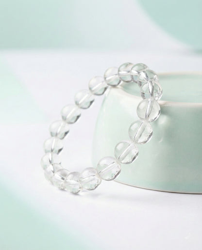 Natural Clear Quartz beaded bracelet with transparent round gemstones on black background.