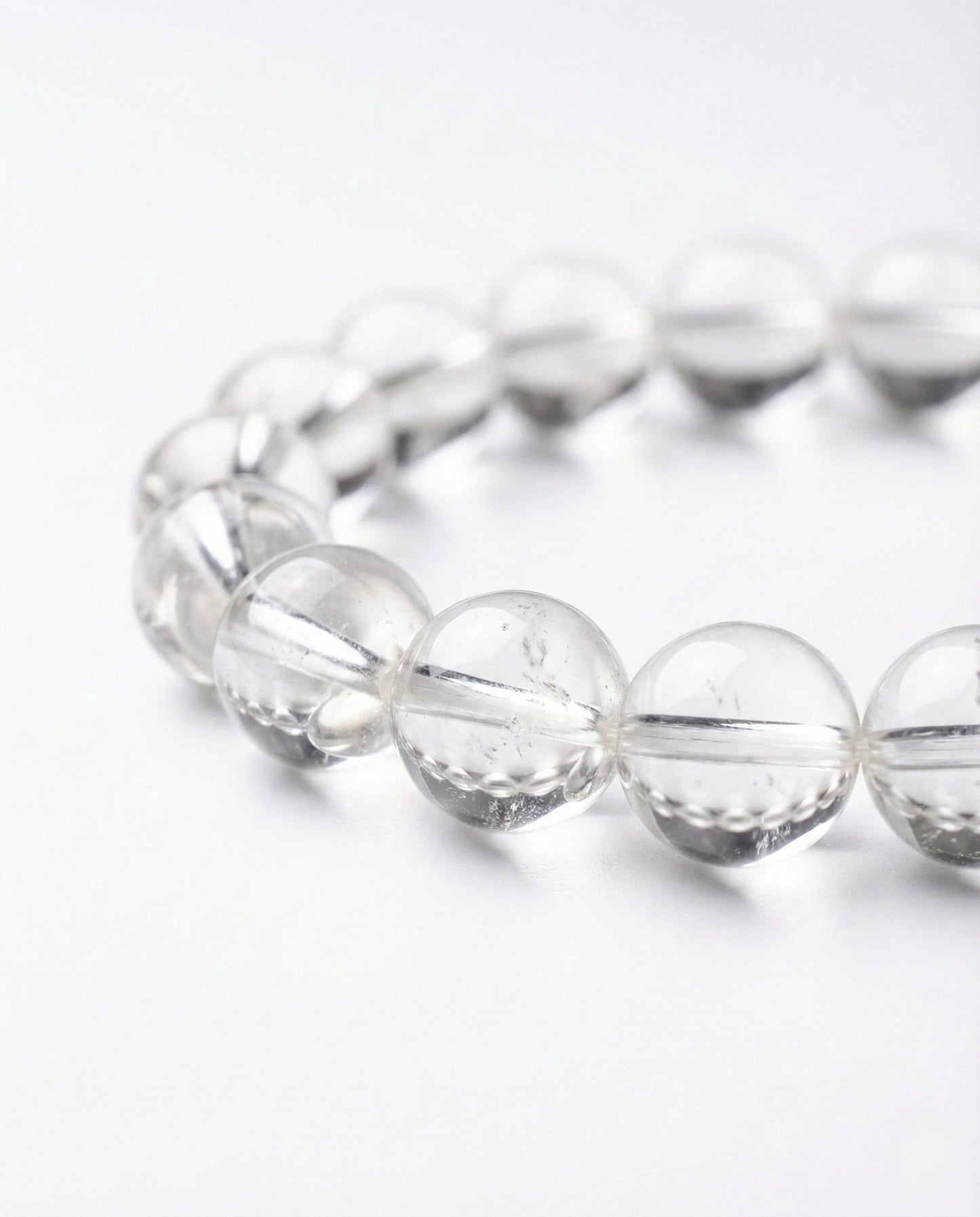 Natural Clear Quartz beaded bracelet with transparent round gemstones on black background.