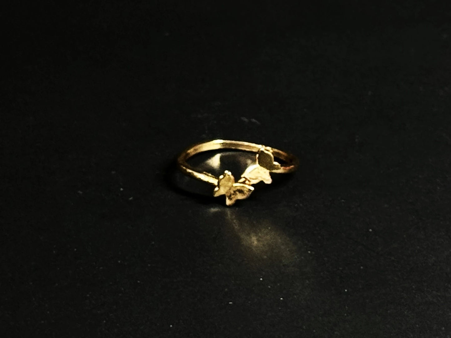 Rose Gold vermeil ring featuring two small butterflies on a dainty band on black background.
