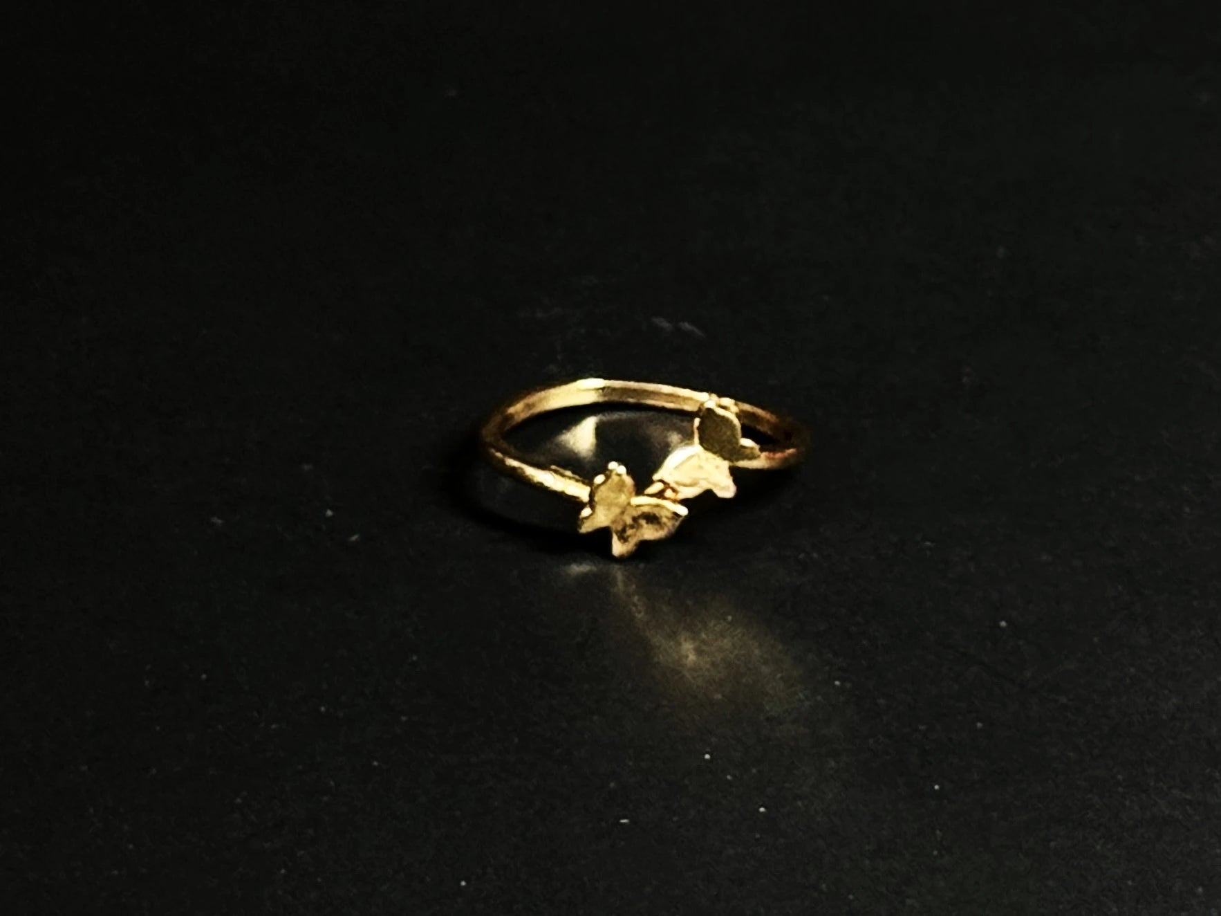Rose Gold vermeil ring featuring two small butterflies on a dainty band on black background.
